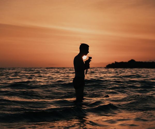Silhouette of a person meditating peacefully against a sunset.